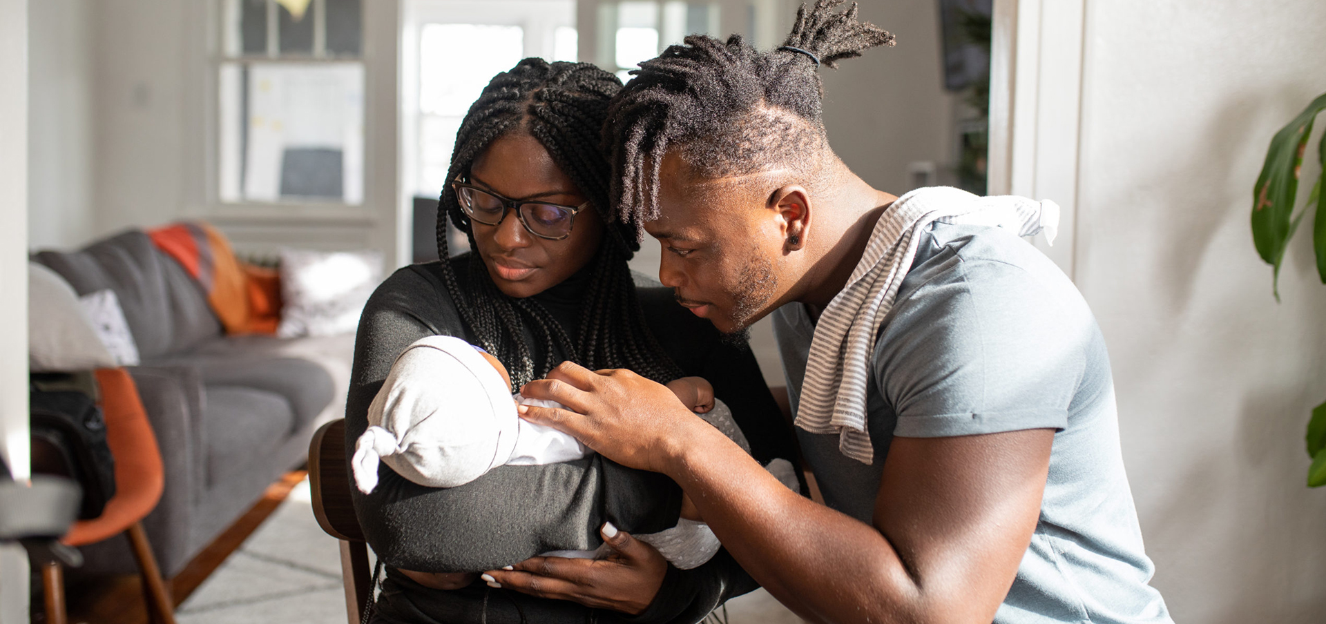 Black couple tending to infant 